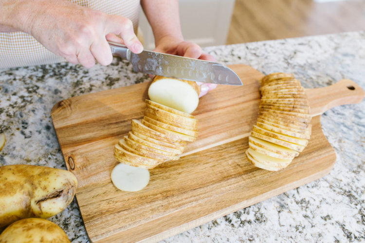 Man chopping potatoes on a board