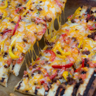 Grilled Flat Bread with Chorizo and Peppers - If you have never made bread on the BBQ you have been missing out! You can make this flat bread with refrigerated pizza dough and be done start to finish in 15 minutes. The BBQ gives this bread the perfect combination of flavors.