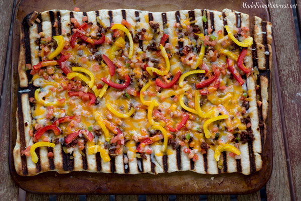 Grilled Flat Bread with Chorizo and Peppers - If you have never made bread on the BBQ you have been missing out! You can make this flat bread with refrigerated pizza dough and be done start to finish in 15 minutes. The BBQ gives this bread the perfect combination of flavors.
