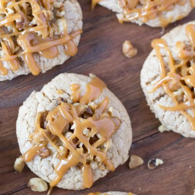 Apple Caramel Cookies - There is a secret ingredient that gives these moist cookies their sweet tangy apple flavor! Stuffed with caramel, topped with walnuts and drizzled with a little more caramel. Best fall cookies EVER!