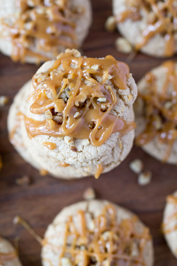 Apple Caramel Cookies - There is a secret ingredient that gives these moist cookies their sweet tangy apple flavor! Stuffed with caramel, topped with walnuts and drizzled with a little more caramel. Best fall cookies EVER!