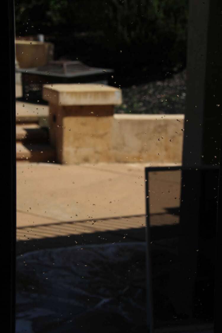 Window with wet spots of water while drying after cleaning