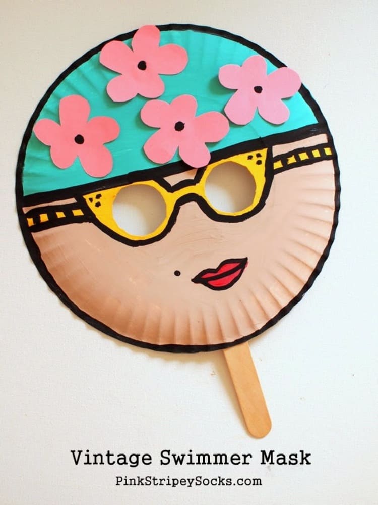 Paper plate craft swimmer mask with yellow sunglasses and red lipstick on a white background