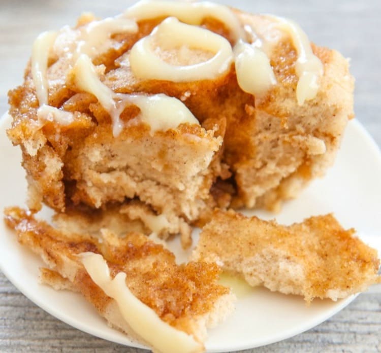 microwave mug snacks cinnamol roll mug cake on a plate with creamy white topping