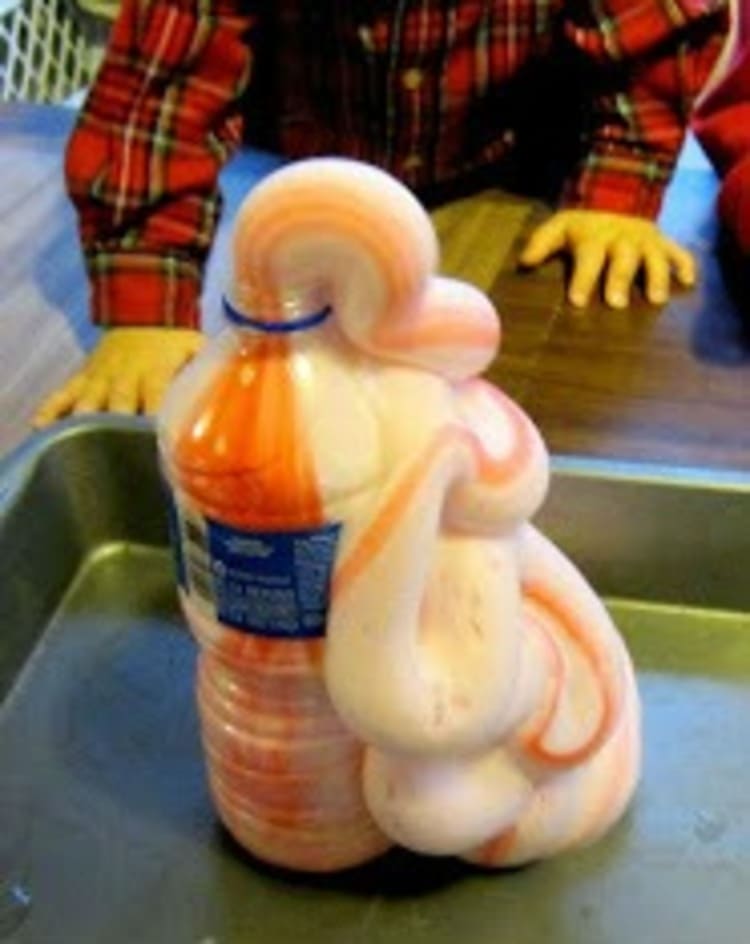 science project for kids elephant toothpaste foam colored in orange and white coming out of a bottle and a kid standing behind it