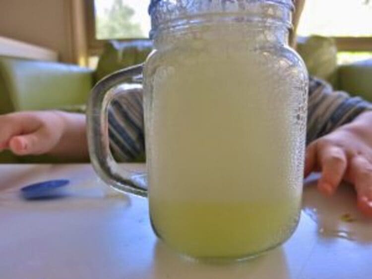 science project fizzing lemonade in a transparent glass on a table