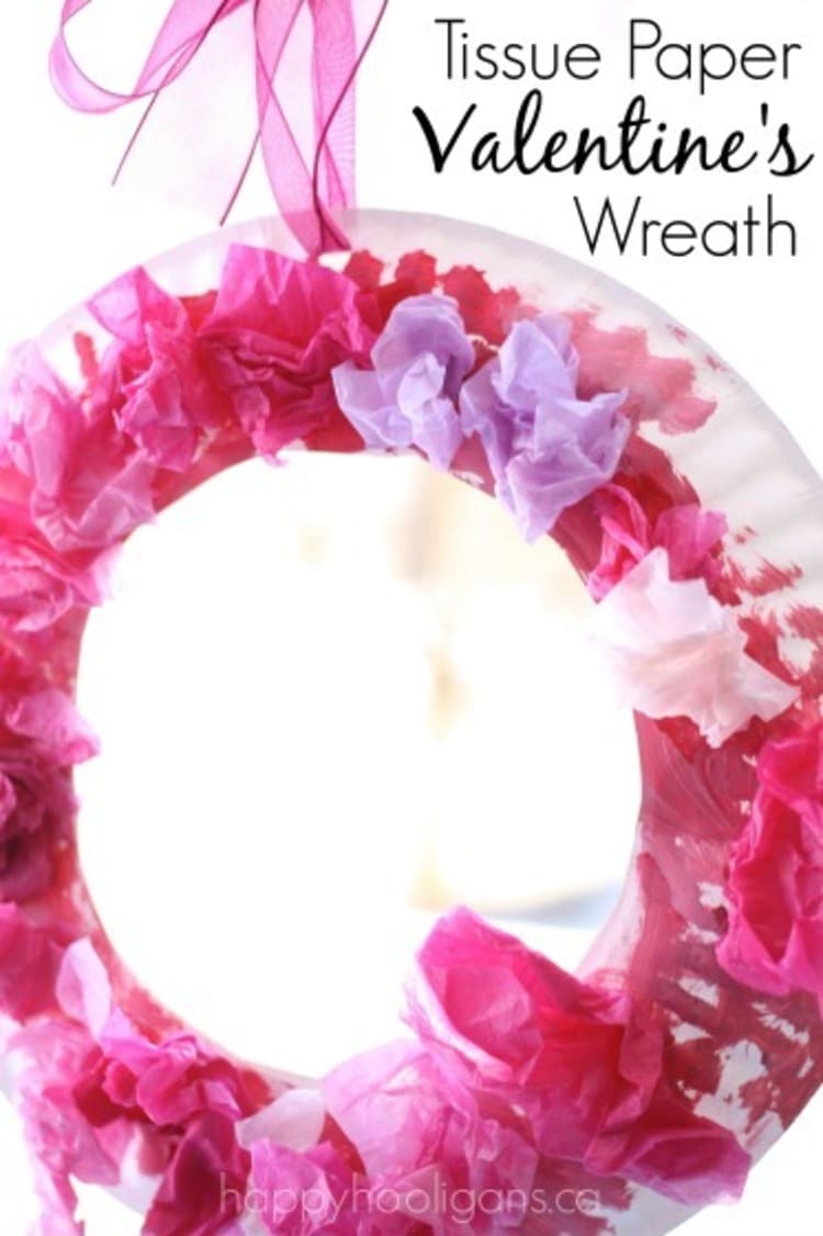 paper plate craft valentine`s day wreath in red and pink colors on a white background