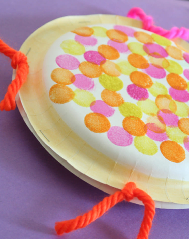 colorful paper plate tambourines on a purple background