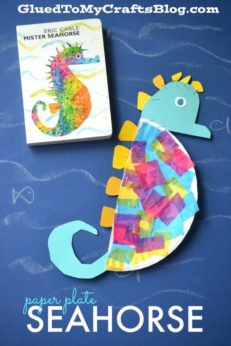 paper plate craft seahorse and a book next to it on a blue background