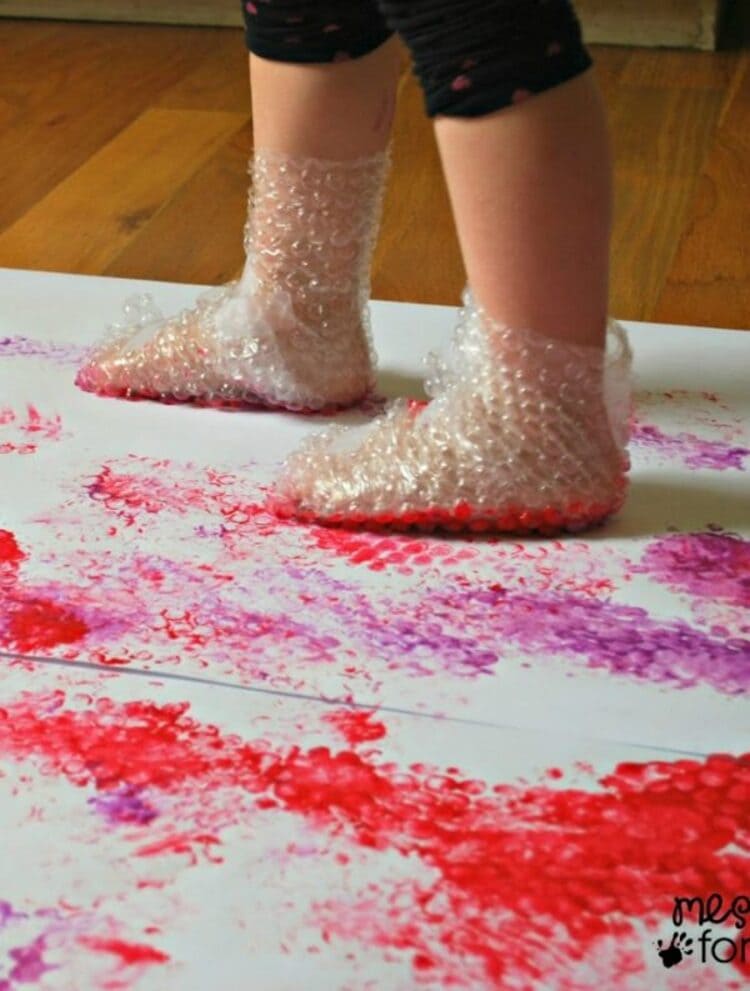 Little legs covered in bubble wrap stomping on paint