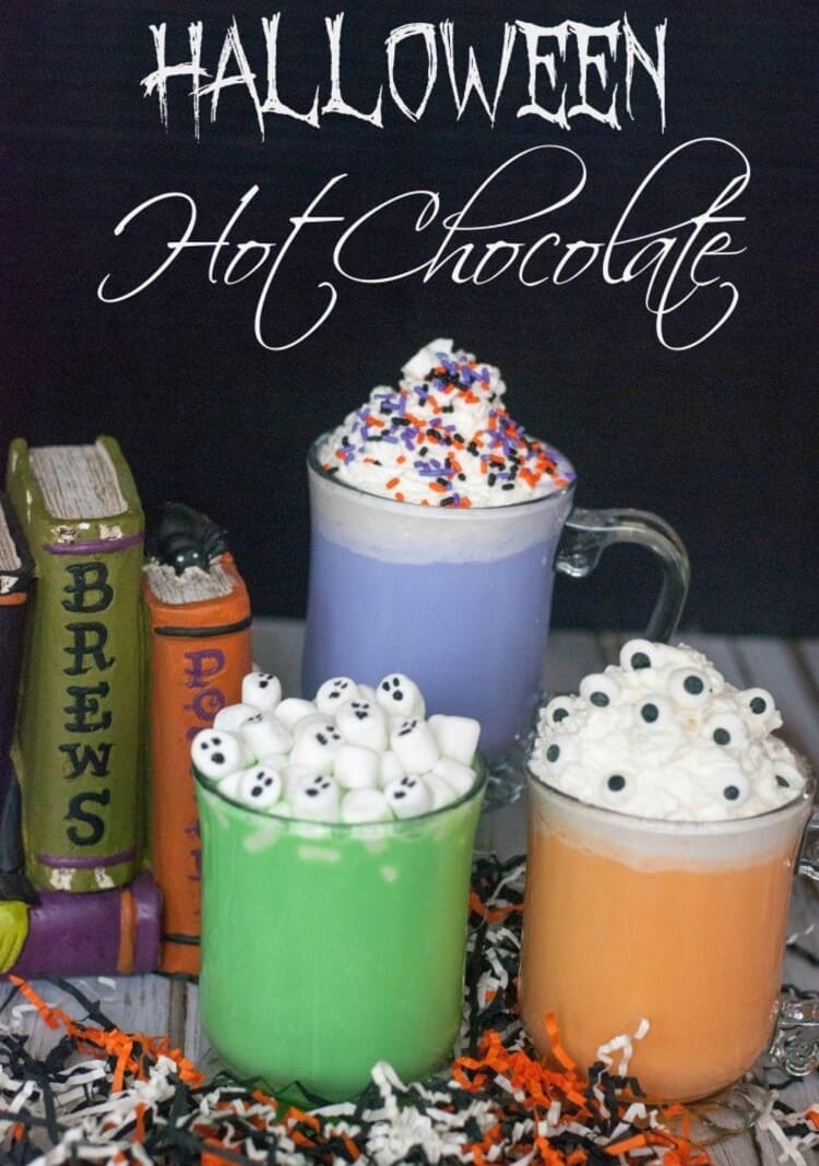 Neon Colored Halloween Hot Chocolate with spooky toppings near spell books