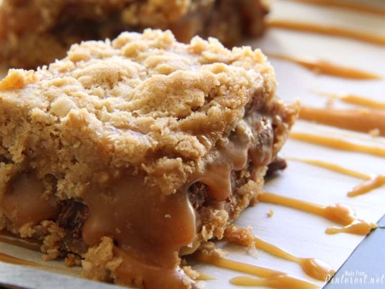 Carmelitas This Grandma Is Fun close up of a carmelitas cookie bar slice with another slice in the background, caramel drizzled on the plate