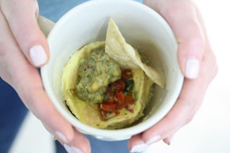 microwave mug snacks chilaquiles in a white cup and hands holding it with white fingernails