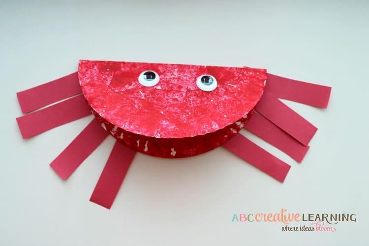 paper plate craft red ocean crab with eight legs and eyes, on a light background