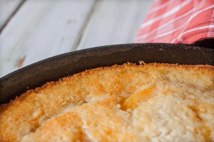 close-up photo of a baked peach cobbler in a baking pan