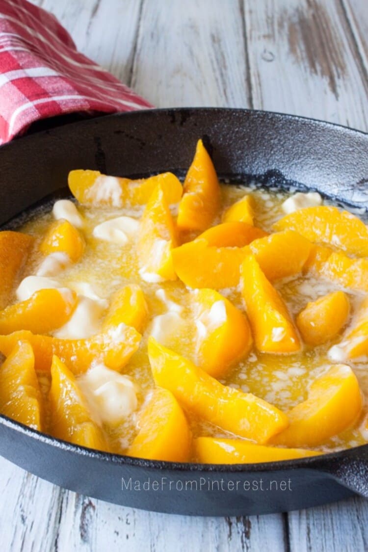 drained canned peaches mixed with melted butter in a 9x13 inch baking pan